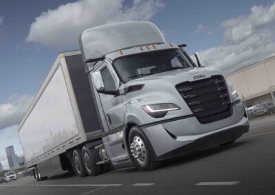 Daimler Truck: Rückenwind aus Nordamerika Ein nordamerikanischer Sattelzug mit einer Zugmaschine vom Typ Freightliner Cascadia fahrend auf einer Straße, fotografiert von schräg vorn (beifahrerseitig)