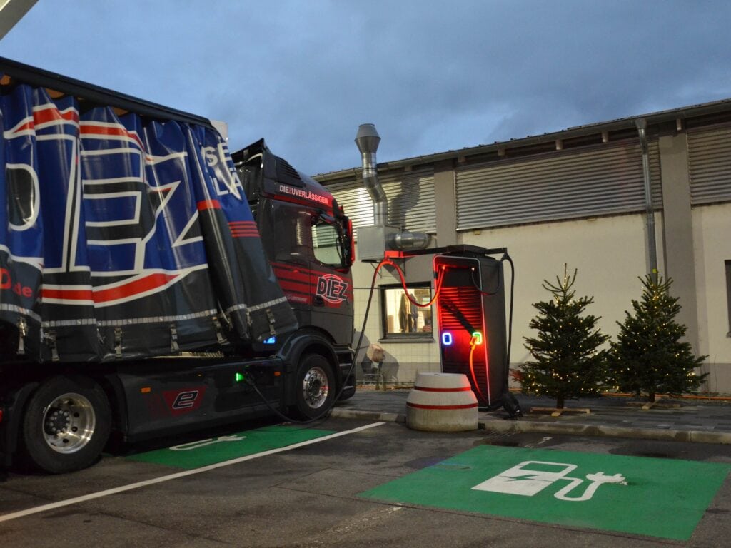 Ein E-Lkw der Spedition Diez lädt in der Abenddämmerung an einer Ladesäule