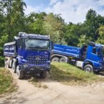 Zwei Baufahrzeuge von Mercedes-Benz Trucks beim Fahren im Gelände
