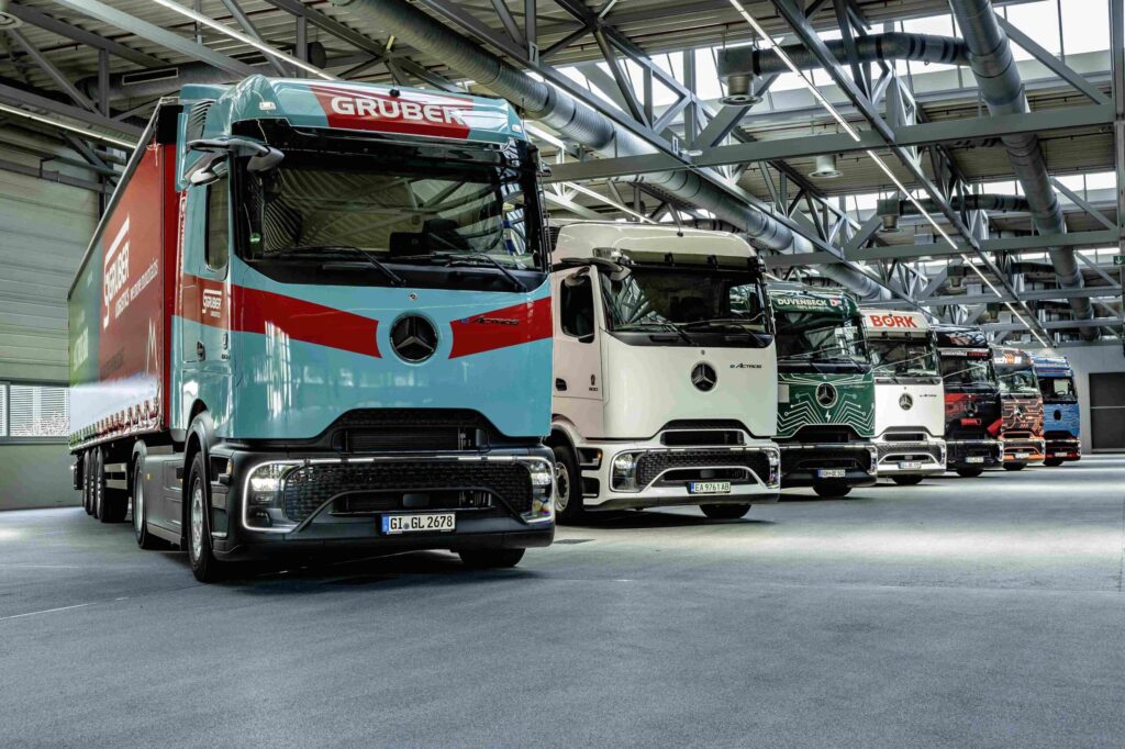 Sieben batterieelektrische Lkw vom Typ Mercedes-Benz eActros 600 nebeneinander in einer Halle