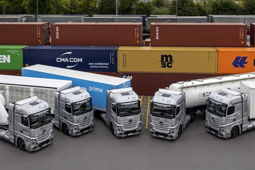 Fünf Brennstoffzellen-Sattelzugmaschinen vom Typ Mercedes-Benz GenH2 Truck nebeneinander