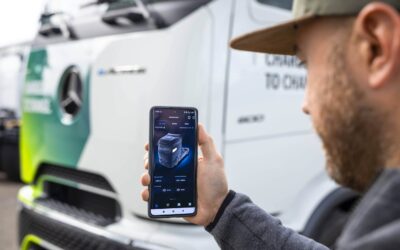 Fahrer hält Mobiltelefon in der Hand, das Daten seine eActros anzeigt