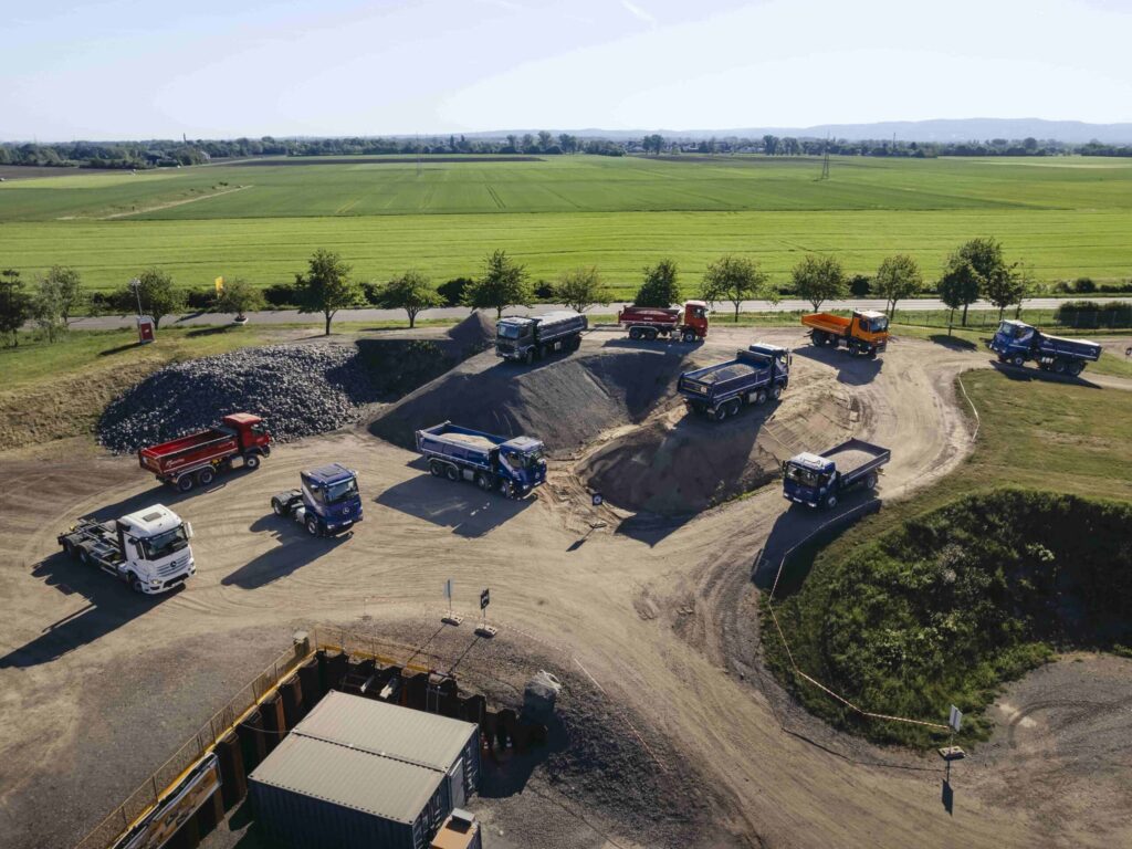 Luftaufnahme vom Offroad-Veranstaltungsgelände COREUM in Stockstadt am Rhein mit verschiedenen Baufahrzeugen von Mercedes-Benz Trucks