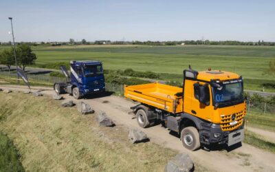 Bild eines Mercedes-Benz Arocs 2240 AK 4x4 vorn und eines Arocs 1853 LS dahinter in einem Baustellenareal