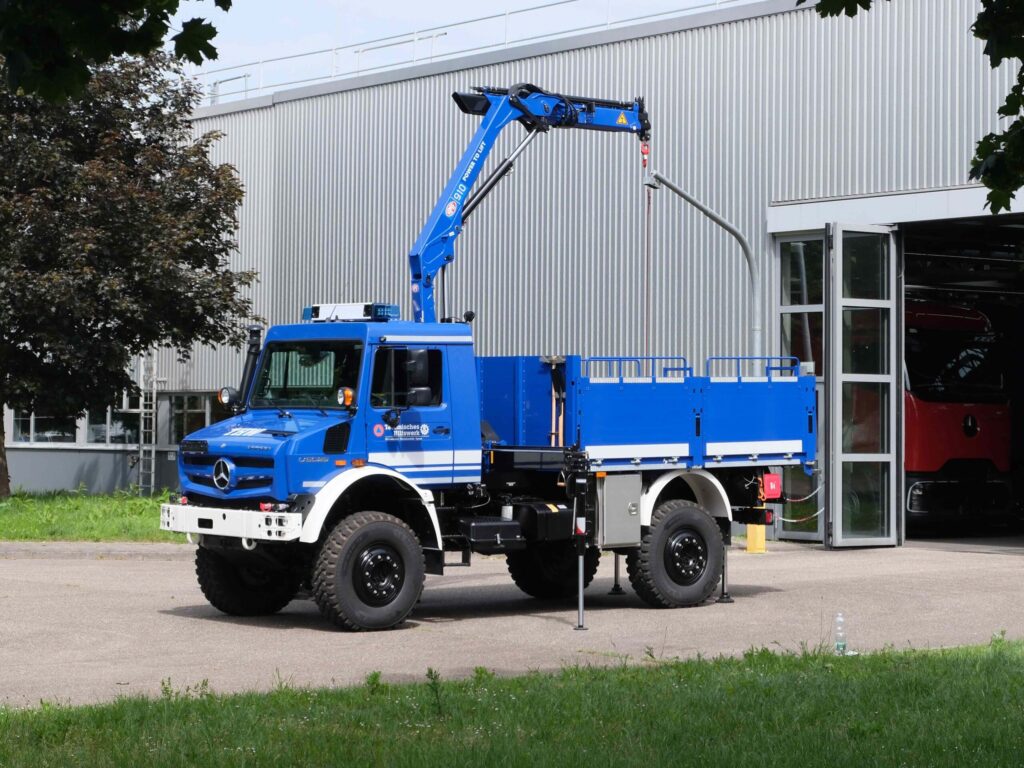 Ein Mercedes-Benz Unimog U 5025 in den Farben des Technischen Hilfswerks mit Kran- und Pritschenaufbau