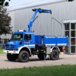 Ein Mercedes-Benz Unimog U 5025 in den Farben des Technischen Hilfswerks mit Kran- und Pritschenaufbau
