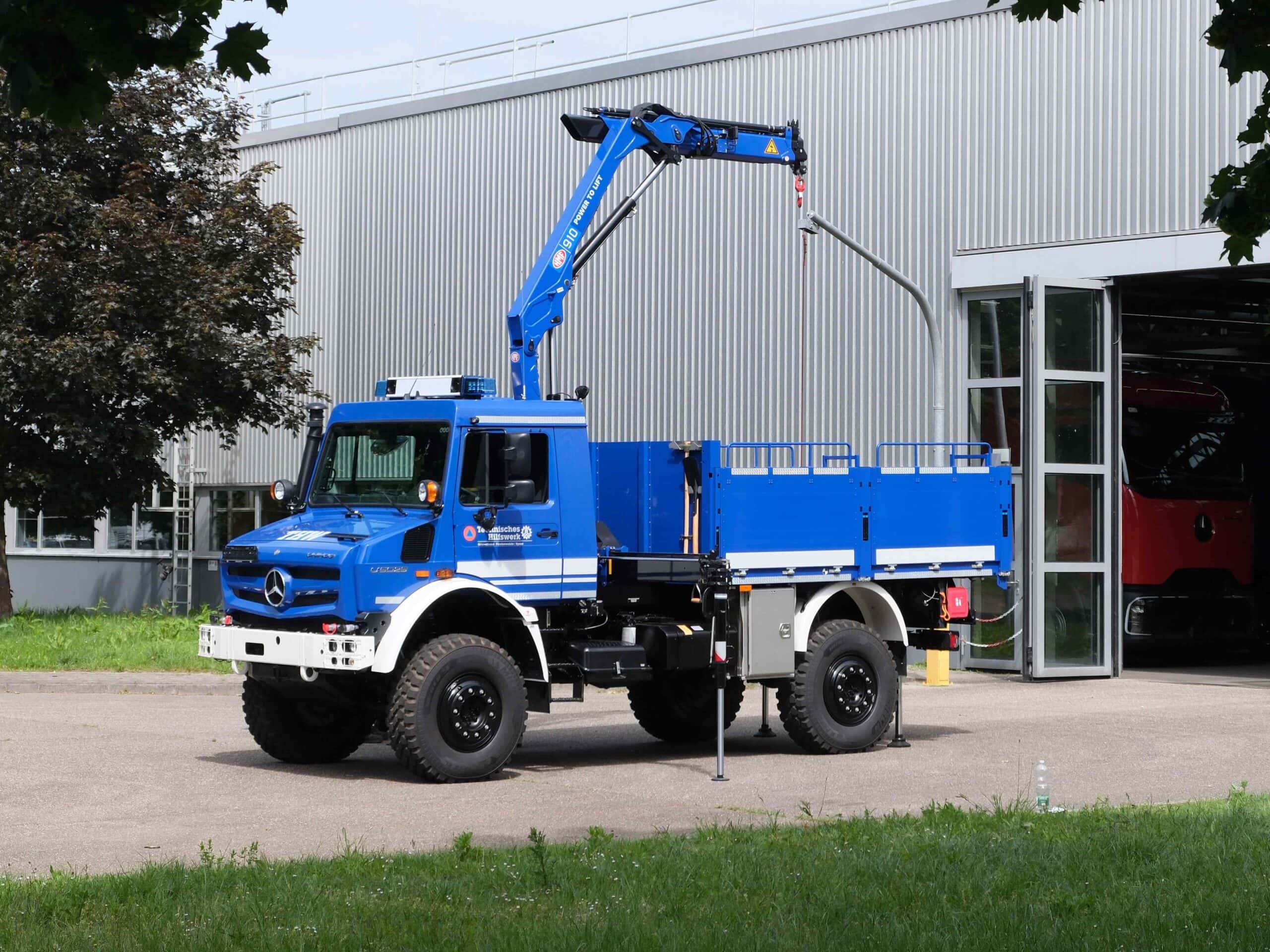 Ein Mercedes-Benz Unimog U 5025 in den Farben des Technischen Hilfswerks mit Kran- und Pritschenaufbau