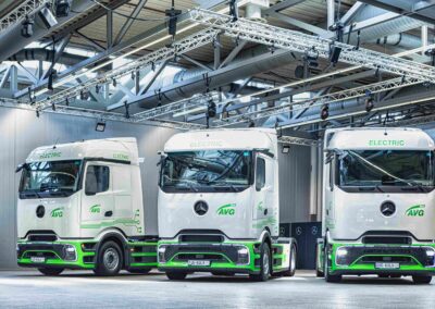 Mercedes-Benz eActros 400 jetzt mit mPTO ab Werk Drei mit den Logos der AVG Köln beschriftete Sattelzugmaschinen Mercedes-Benz eActros 400 nebeneinander in einer Halle