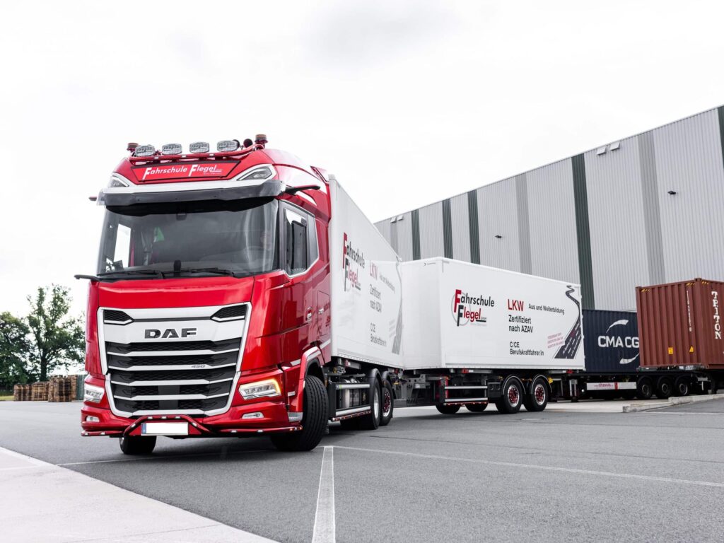 Ein Fahrschul-Lkw mit Anhänger probt an einer Laderampe das Rangieren rückwärts