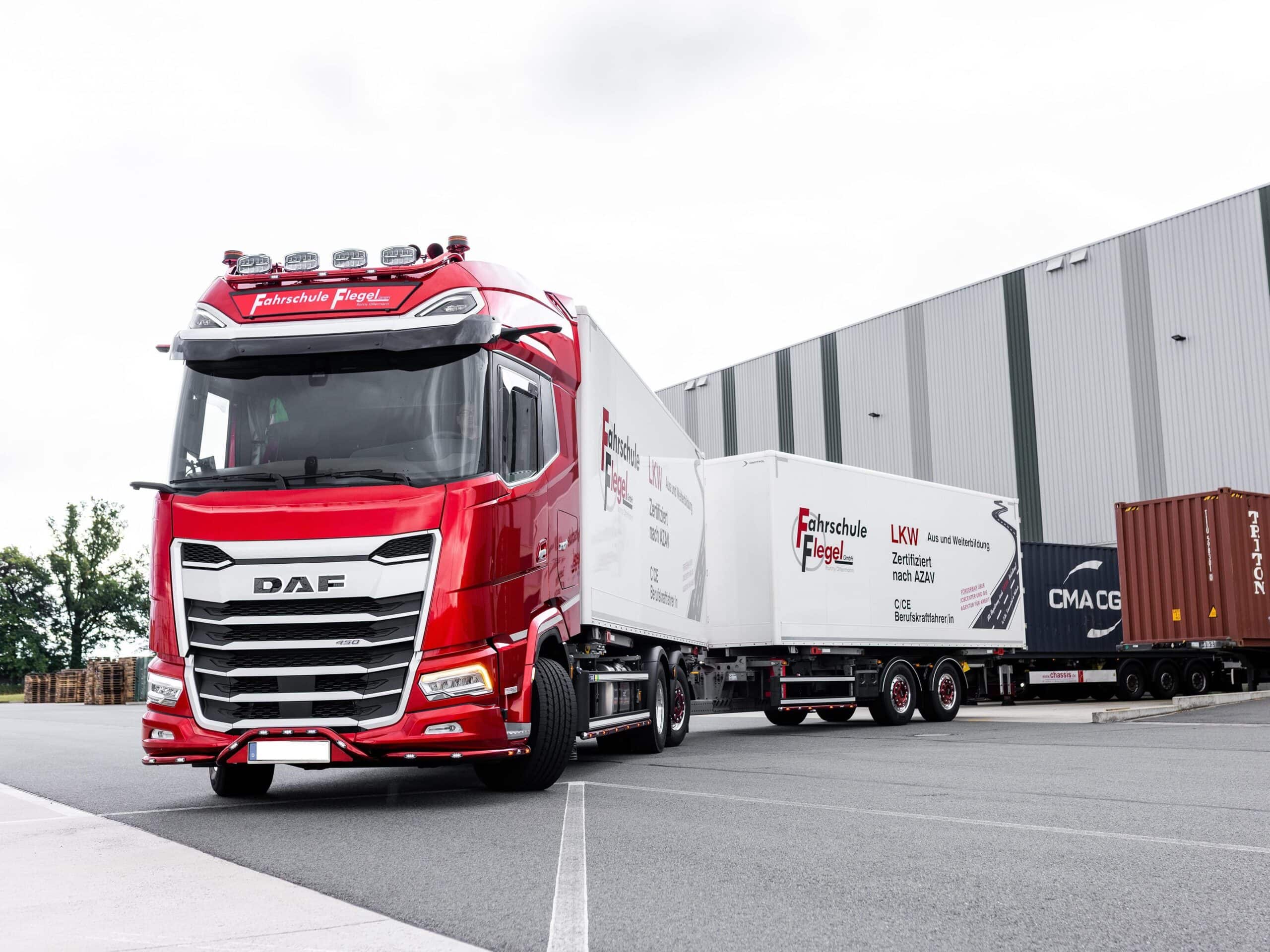 Ein Fahrschul-Lkw mit Anhänger probt an einer Laderampe das Rangieren rückwärts