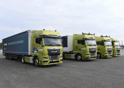 Autonom über EU-Ländergrenzen hinweg Vier Prototypen autonom fahrender Sattelzüge auf Basis MAN nebeneinander auf einem Parkplatz