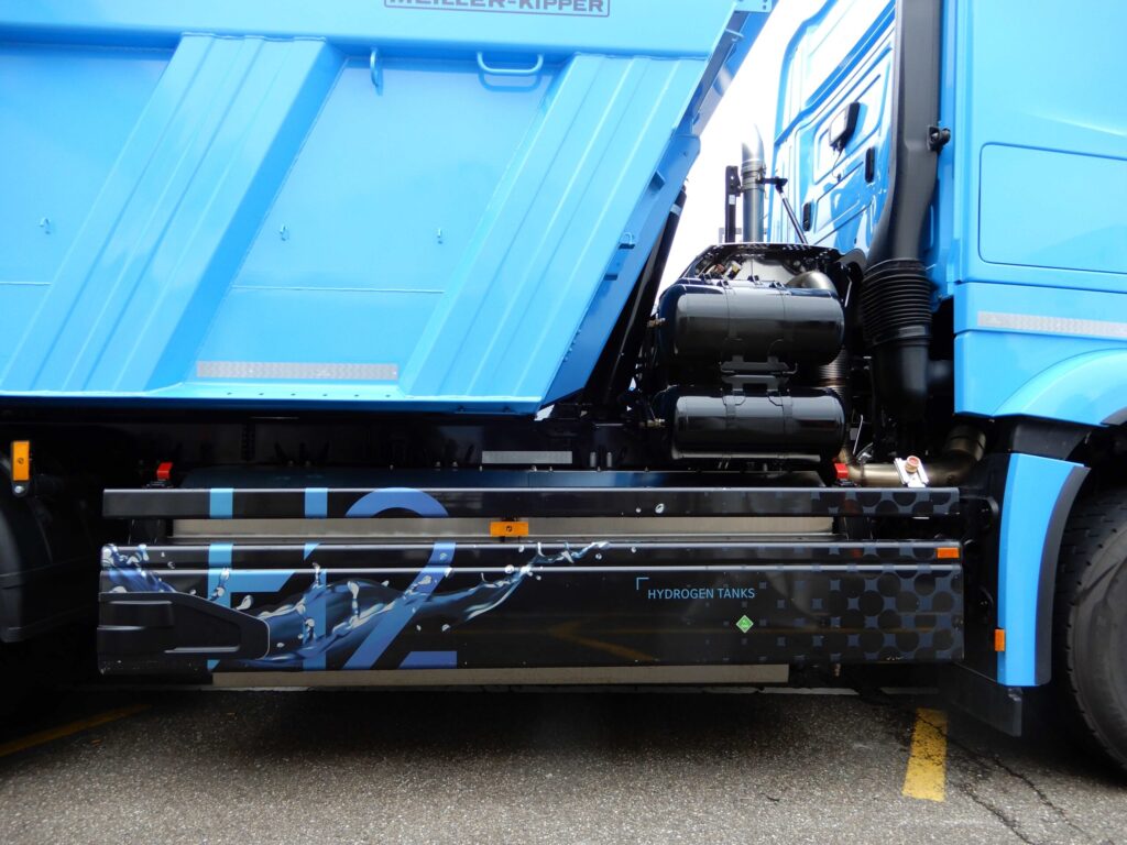 Seitenansicht (Beifahrerseite) eines Versuchsträgers mit Wasserstoffmotor auf Basis eines Mercedes-Benz Arocs; man sieht die Wasserstofftanks hinter der Fahrerkabine