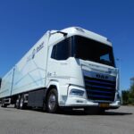 Ein Gliederzug mit einem batterieelektrischen DAF XF 350 FAN Electric 6x2 Sleeper High Cab auf einem Parkplatz