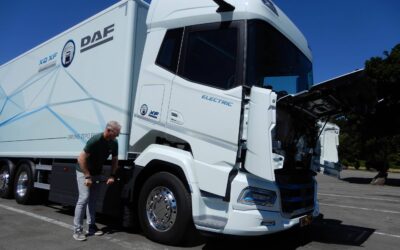 Ein Fahrer betätigt an einem batterieelektrischen DAF XF 350 FAN Electric 6x2 Sleeper High Cab die manuelle Pumpe zum Kippen des Fahrerhauses
