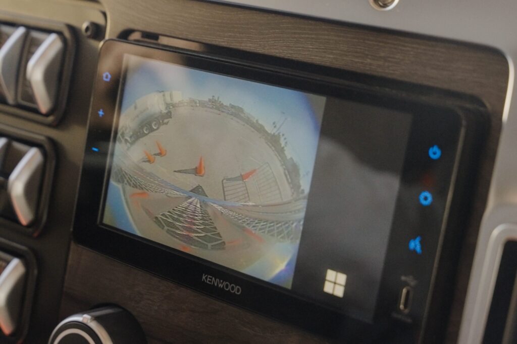 Blick auf das Touchscreen-Sekundärdisplay in einem US-amerikanischen Hauben-Lkw von Daimler Truck; auf dem Monitor wird eine 360-Grad-Sicht um das Fahrzeug angezeigt