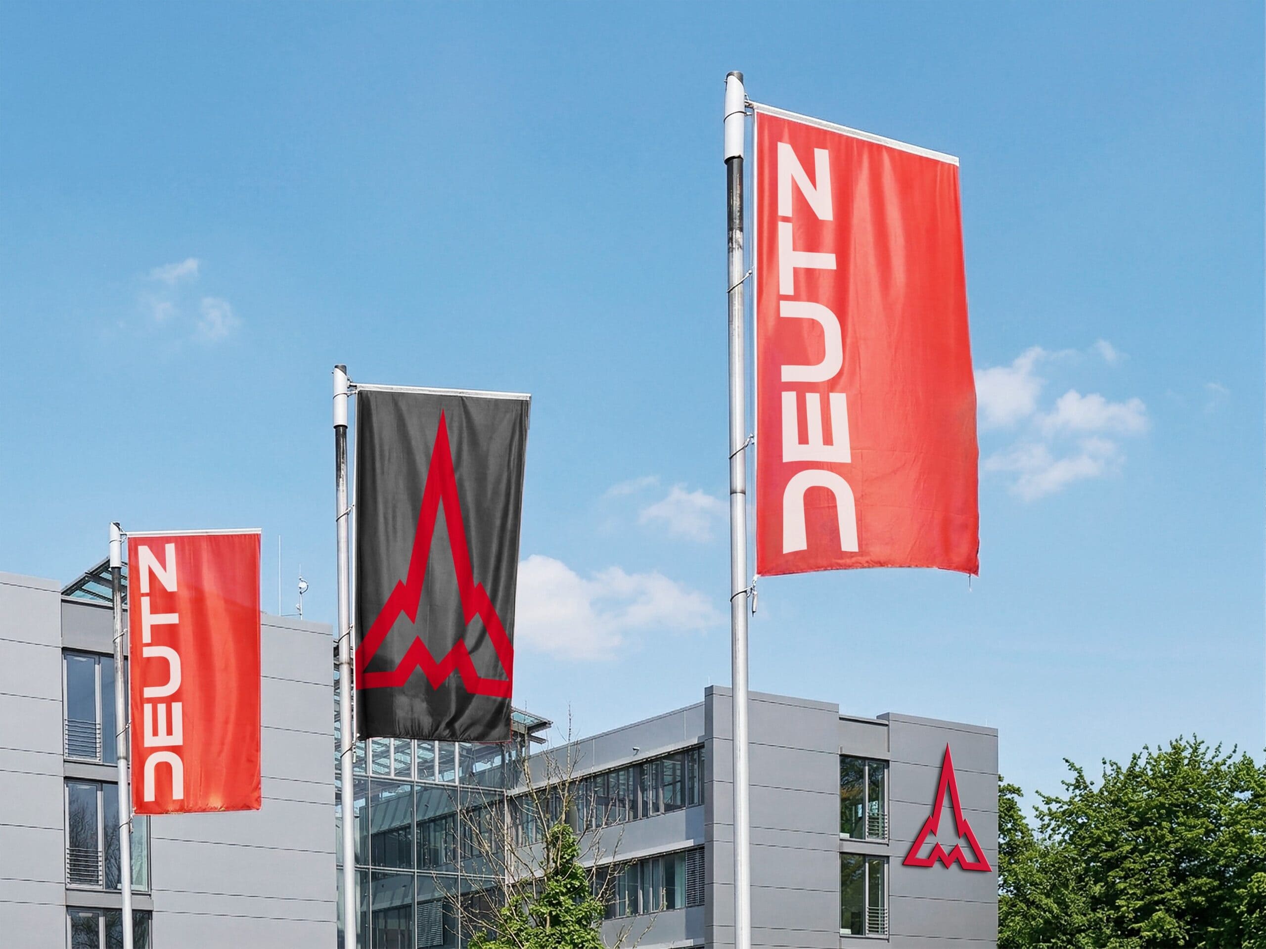 Blick auf die Hauptverwaltung der Deutz AG in Köln-Porz, im Vordergrund wehen Fahnen mit dem neuen Unternehmenslogo