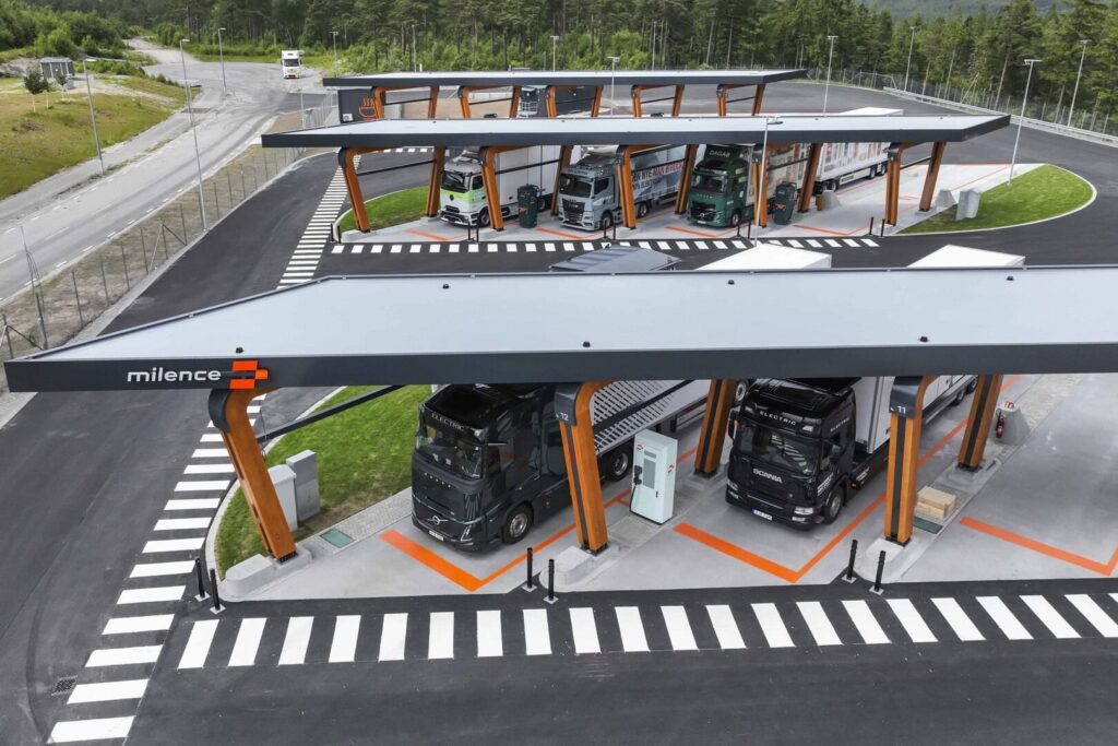 Ein Ladepark für Elektro-Lkw von Milence von schräg oben; es sind insgesamt fünf Lastzüge an Ladesäulen zu sehen