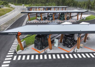 Ein Ladepark für Elektro-Lkw von Milence von schräg oben; es sind insgesamt fünf Lastzüge an Ladesäulen zu sehen