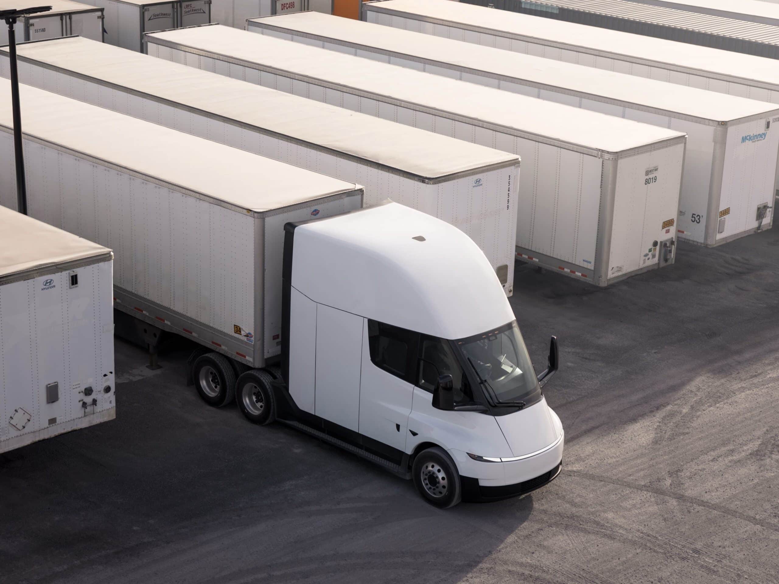Eine batterieelektrische Sattelzugmaschine vom Typ Tesla Semi auf einem Terminalgelände mit zahlreichen abgestellten Sattelaufliegern