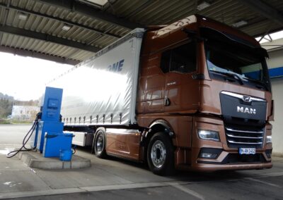 Ein Sattelzug mit einer MAN-Sattelzugmaschine steht neben einer Diesel-Zapfsäule