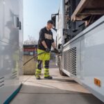 Ein Mann betankt an einer Wasserstofftankstelle einen Lkw