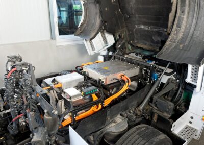 Blick unter das Fahrerhaus eines zum BEV umgerüsteten Lkw mit E-Motor und Leistungselektronik