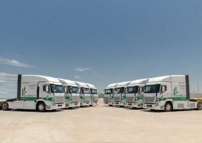 Acht Brennstoffzellen-Sattelzugmaschinen Hyundai Xcient Fuel Cell, je zwei Vierergruppen links und rechts, auf einem Parkplatz in Uruguay