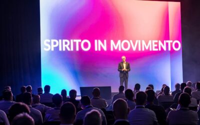 Ein Redner steht anlässlich der „Spirito in Movimento“ Tour von Iveco auf einer Bühne, im Vordergrund sitzt das Publikum mit dem Rücken zur Kamera