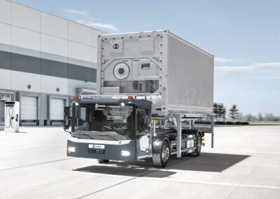 Ein batterieelektrischer Wechselbrückenumsetzer Kamag ePM 101 transportiert auf einem Betriebshof eine Wechselbrücke