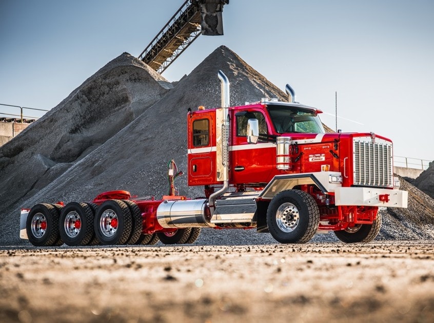 Vierachsige Sattelzugmaschine vom Typ Kenworth C580 auf einer Baustelle. Eine Vorderachse und Tridem-Aggregat hinten