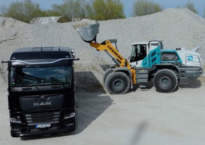Ein Liebherr-Radlader L 566 H mit Wasserstoffverbrenner belädt den Kippsattel an einem MAN hTGX