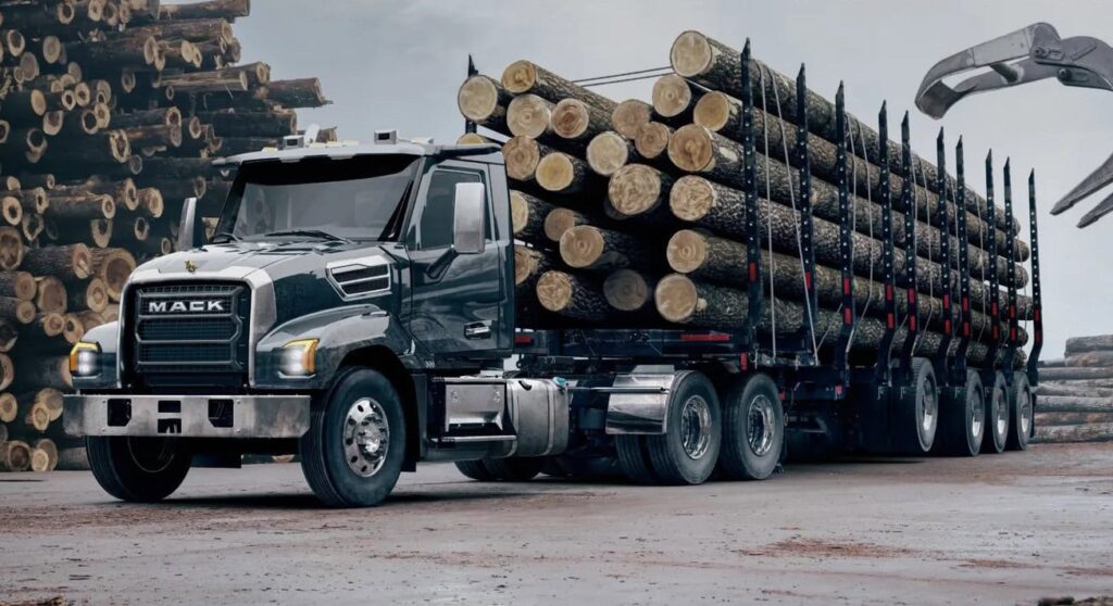 US-amerikanischer Hauben-Lkw vom Typ Mack Keystone mit einem Holztransport-Sattelauflieger voller Langholz