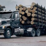 US-amerikanischer Hauben-Lkw vom Typ Mack Keystone mit einem Holztransport-Sattelauflieger voller Langholz