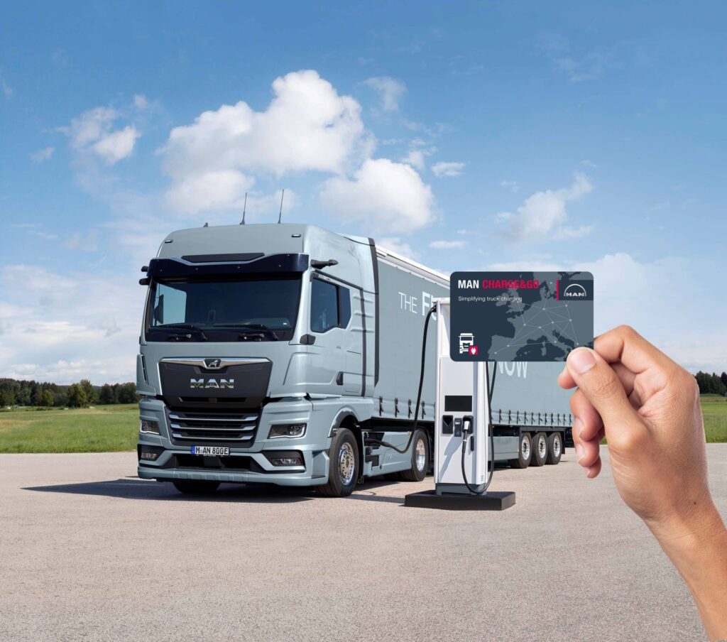 MAN eTGX an Elektro-Ladesäule, im Vordergrund eine Hand mit Charge & Go-Bezahlkarte