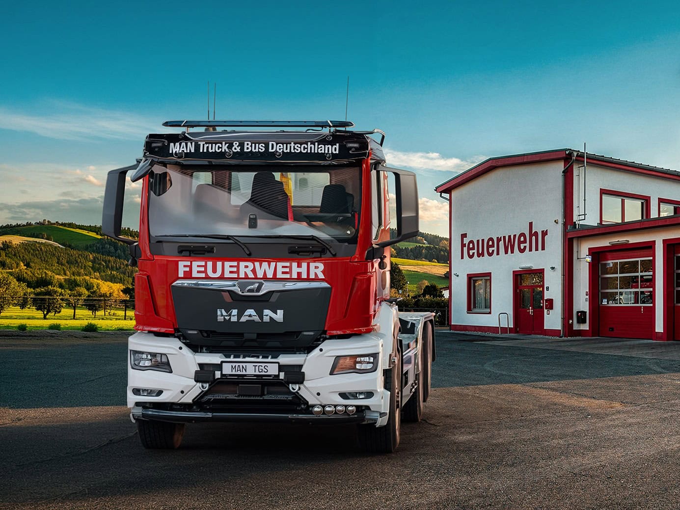 Feuerwehr-Wechsellader auf Basis MAN, Frontansicht vor einer Feuerwache