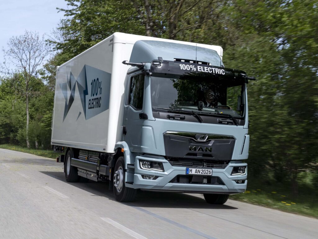 Ein batterieelektrischer Lkw vom Typ MAN eTGM mit Kofferaufbau auf einer Landstraße; Zweiachser