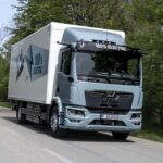 Ein batterieelektrischer Lkw vom Typ MAN eTGM mit Kofferaufbau auf einer Landstraße; Zweiachser