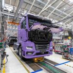 Blick auf eine Fertigungsstraße im Werk von MAN in München; ganz vorn ein batterieelektrischer eTGX, dahinter weitere in Produktion befindliche Lkw