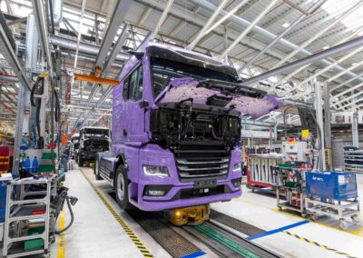 Blick auf eine Fertigungsstraße im Werk von MAN in München; ganz vorn ein batterieelektrischer eTGX, dahinter weitere in Produktion befindliche Lkw