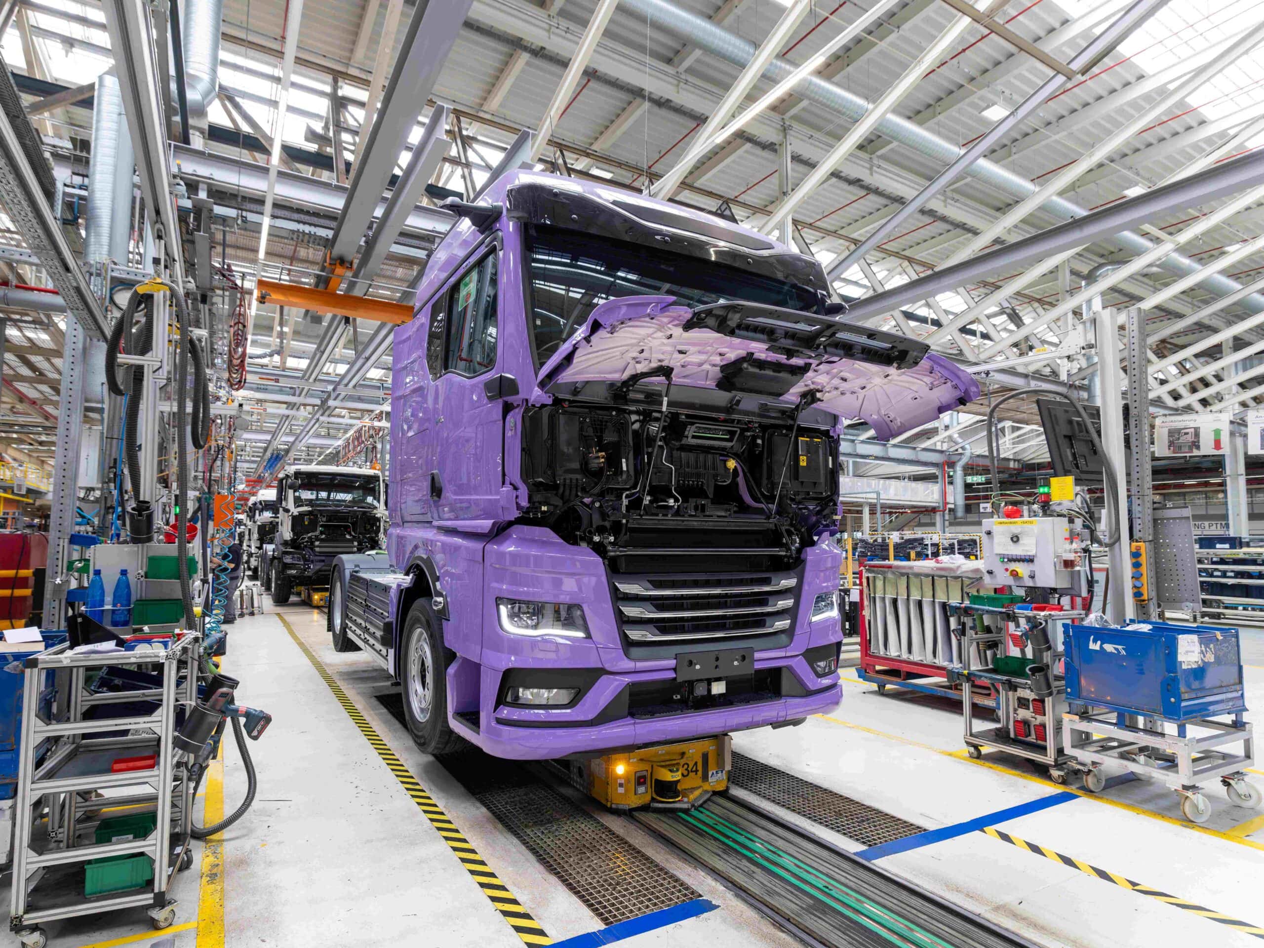 Blick auf eine Fertigungsstraße im Werk von MAN in München; ganz vorn ein batterieelektrischer eTGX, dahinter weitere in Produktion befindliche Lkw