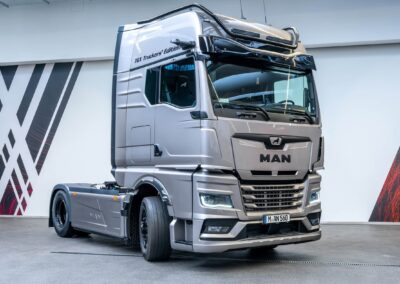 Silberfarbene 4x2-Sattelzugmaschine aus der limitierten Sondermodellreihe MAN TGX Truckers‘ Edition, fotografiert in einem Ausstellungsraum