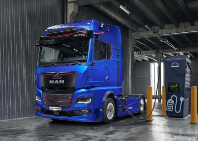 IAA-Premiere: Neufassung des MAN eTGX Batterieelektrische Sattelzugmaschine vom Typ MAN eTGX in einer Halle mit angeschlossenem Ladeanschluss an einer Ladesäule