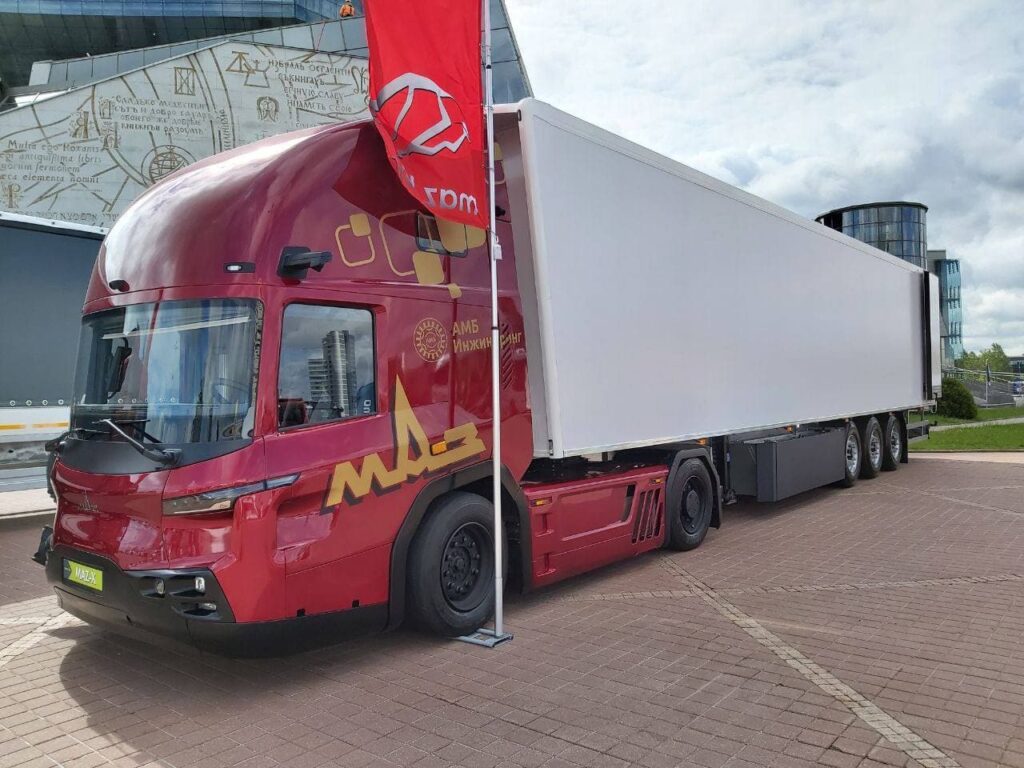 Sattelzug mit Kühlauflieger und Sattelzugmaschine MAZ-545000 mit Niederflurfahrerhaus und dieselelektrischem Antrieb auf einem Messestand im Freien