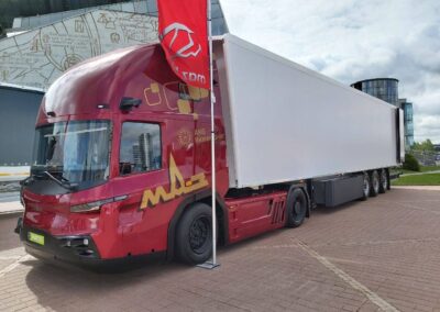 MAZ: Moderne Zeiten in Belarus Sattelzug mit Kühlauflieger und Sattelzugmaschine MAZ-545000 mit Niederflurfahrerhaus und dieselelektrischem Antrieb auf einem Messestand im Freien