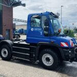 Ein batterieelektrischer ET400 von Orten Electric Trucks auf Unimog-Basis steht auf einem Betriebshof vor einer Halle