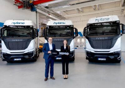 Drei Brennstoffzellen-Lkw vom Typ Iveco S-eWay Fuel Cell, davor Christian Sulser, Vorstandsvorsitzender der Iveco Magirus AG, und Hylane-Geschäftsführerin Dr. Sara Schiffer.