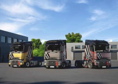 Drei Sattelzugmaschinen von Renault Trucks in der Version T High Ultimate Edition in den Farbvarianten Gold, Grau und Violett (von links nach rechts) nebeneinander, solo ohne Sattelauflieger