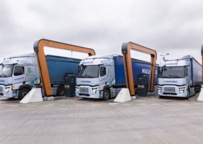 Drei Elektro-Lastzüge des französischen Transportunternehmens Malherbe stehen an einer Ladestation nebeneinander