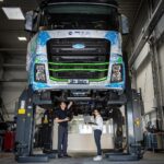 Ein schwerer Elektro-Lkw aus dem Projekt „SeLv“ auf einer Hebebühne, darunter ein Mann und eine Frau mit Messgeräten und Laptop