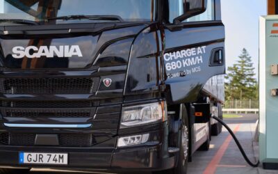 Ein batterieelektrischer Lkw von Scania steht an einer MCS-Ladestation, um bidirektionales Laden zu demonstrieren